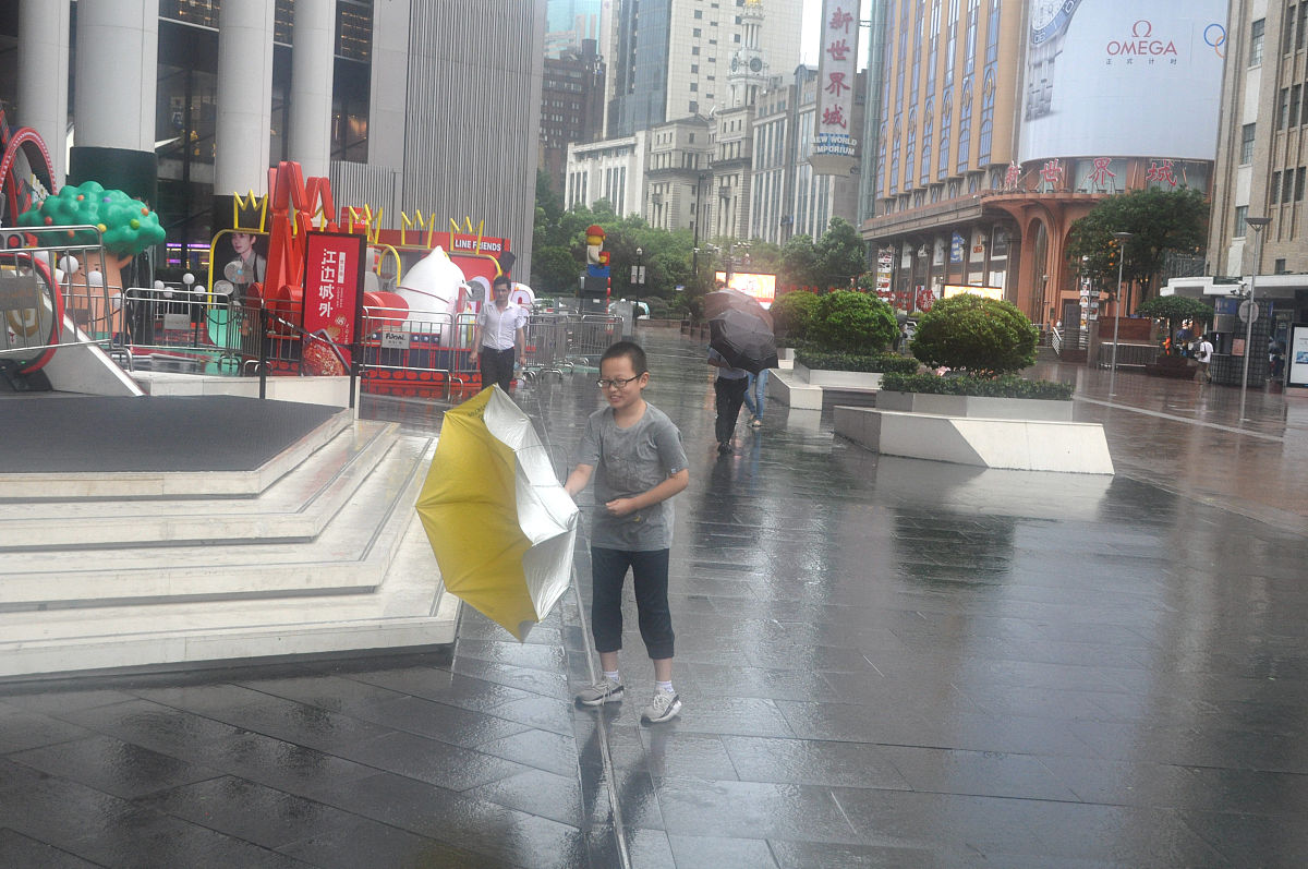 2021年7月25日,受台风"烟花"影响,上海风雨交加,南京路步行街市民游客