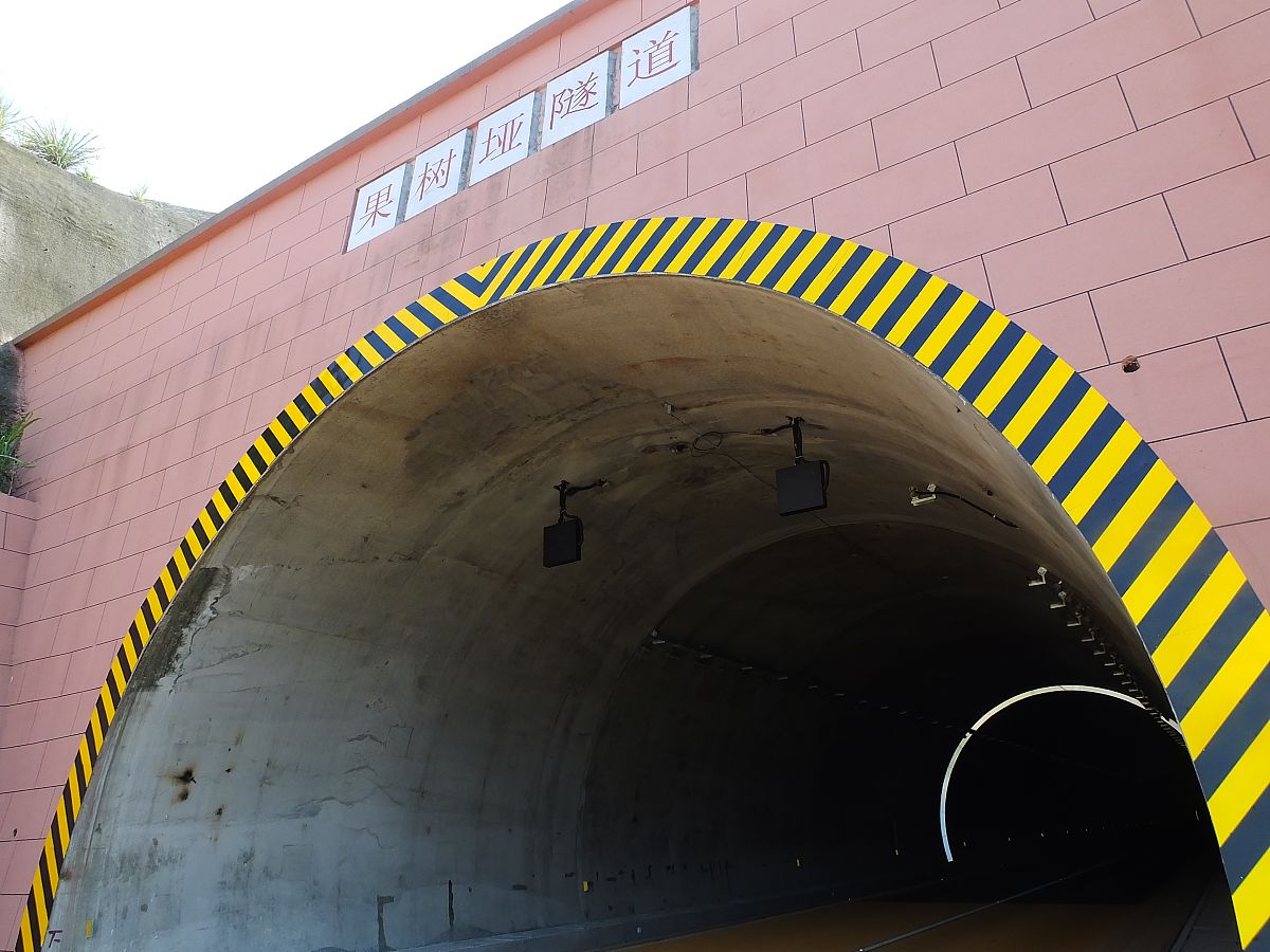 帮我根据这段话三联路共设置隧道 1 处为双向六车道连拱隧道隧道长度 510m。其中拟建山岭段隧道工程为左右幅分离式隧道设计里程为 K1+135～K1+433设计长度为 298m隧道底板设计标高 5302m～6120m；山岭段隧道施工方法拟采用钻爆法暗挖洞壁支护形式拟采用复合式衬砌结构。设计隧道沿线最高山顶标高超过 125m植被较发育西端洞口为现状边坡地形较陡且邻近密集居民住宅区大型设备通行较困难。