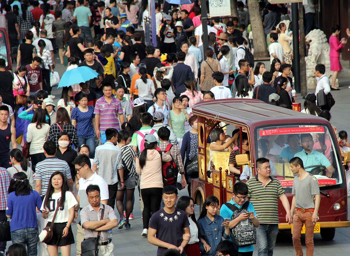 用中文根据提示重新写一篇长篇文章：五一假期期间大量人潮汹涌涌地涌向各大景点人山人海的场面令人思考：究竟是穷人在消费还是富人在赚钱？