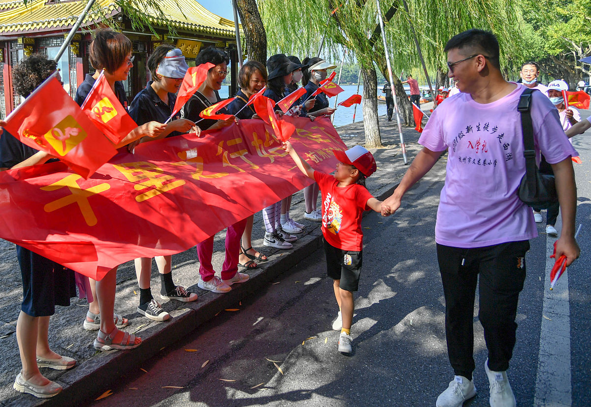 2021年8月29日上午,杭州文龙巷小学的老师在西湖白堤上为参加徒步走活
