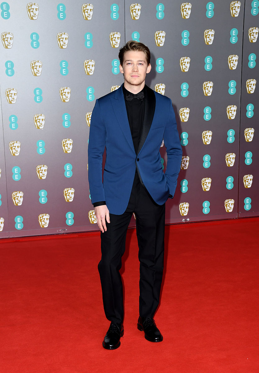 请设计一个古装男主角人设详细描述外貌包括五官形状大小排布衣着打扮发型饰品妆容颜色特色。另外请概括一下她的身份背景和性格特点。