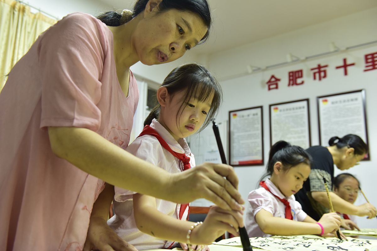 2020年8月9日,书法家杨兴玲在手把手教合肥市十里庙小学书画社团的小