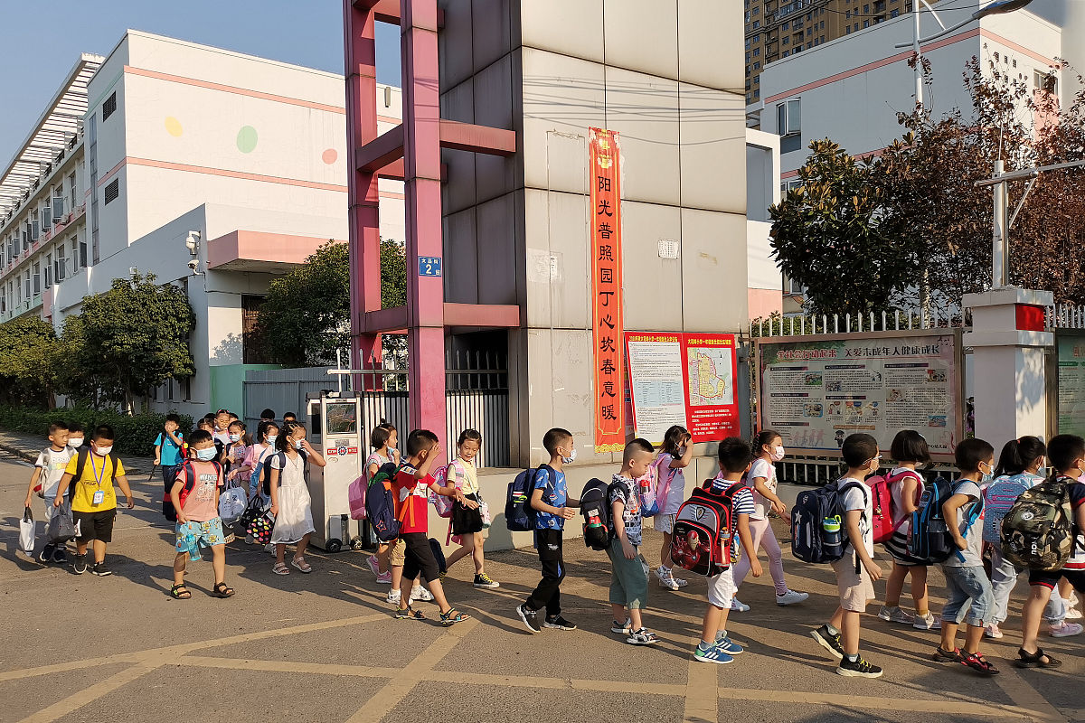 2020年9月4日下午,武汉大花岭,一墙之隔的幼儿园和小学门口重现接孩子