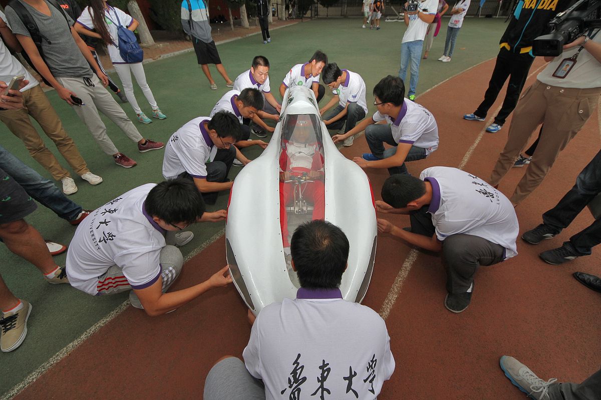 2014年09月16日,在山东烟台鲁东大学,试车手坐进驾驶室后,学生们正在