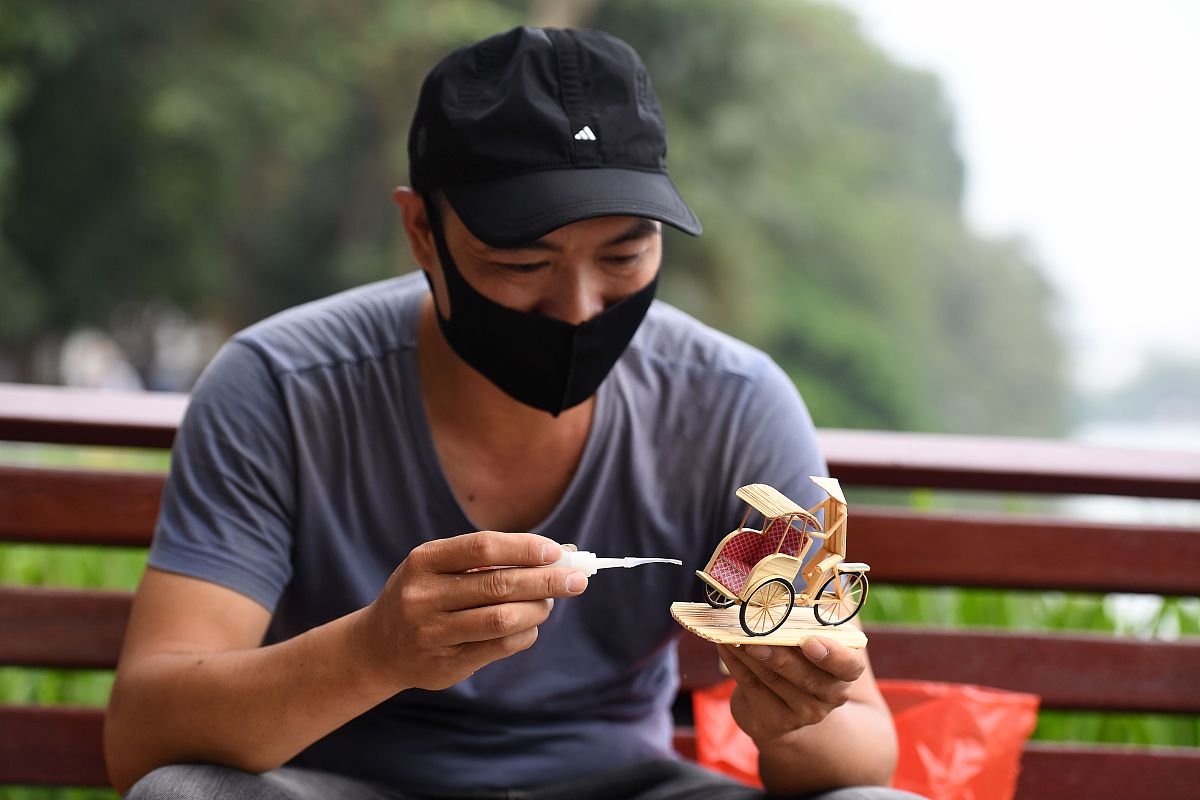 当地时间2020年11月25日,越南河内,一名越南男子展示他制作的微缩竹雕