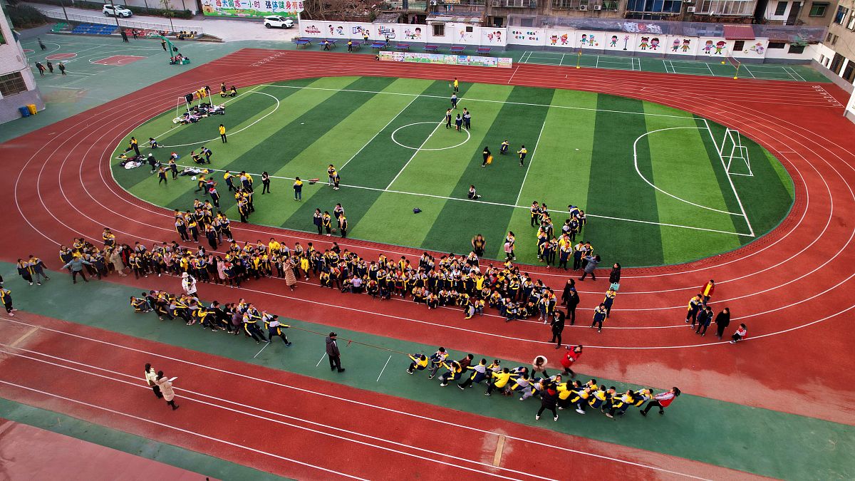 2021年12月30日,湖北襄阳,宜城市西街小学学生在运动场上拔河.