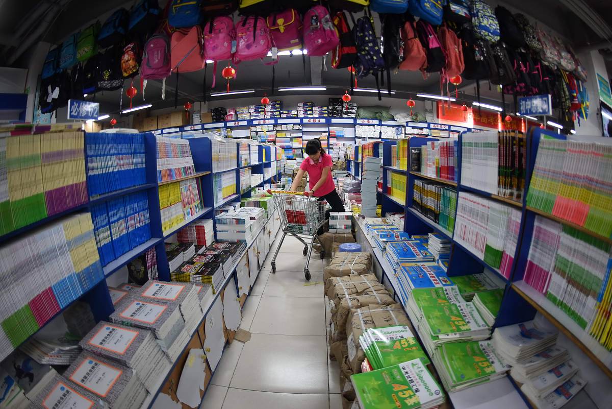 2015年8月23日,海南琼海市,一家书店工作人员正将教辅资料摆放上架.