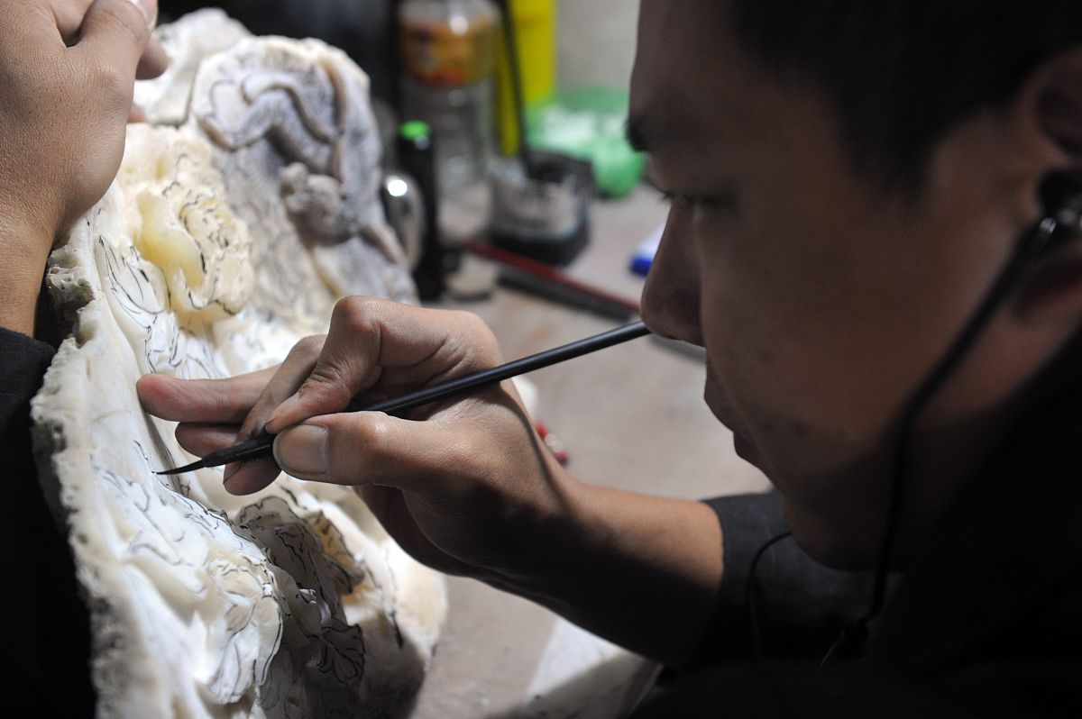 2013年11月28日,海南琼海,技师正在雕刻贝类工艺品.