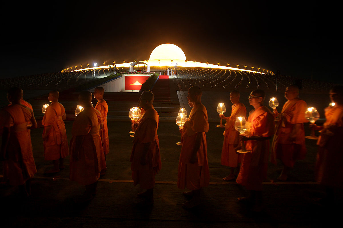 2012年3月7日,泰国巴吞他尼府,数千名僧侣坐在灯烛旁诵经,庆祝万佛节.