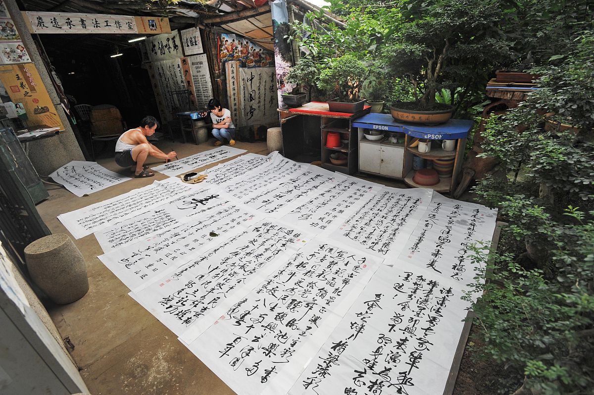 2015年7月20日,大李村一隅,严远承在自家院中研习书法.