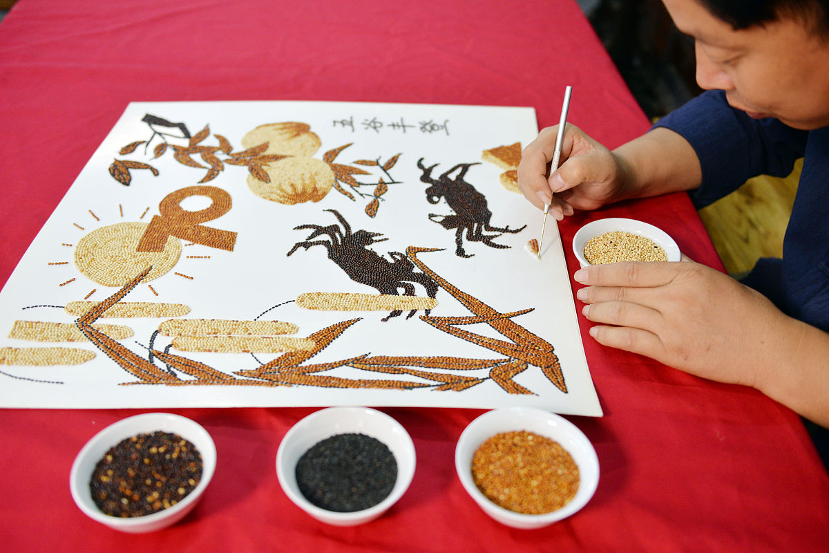2019年9月23日,山东聊城,民间艺人刘立增在现场制作"五谷画".