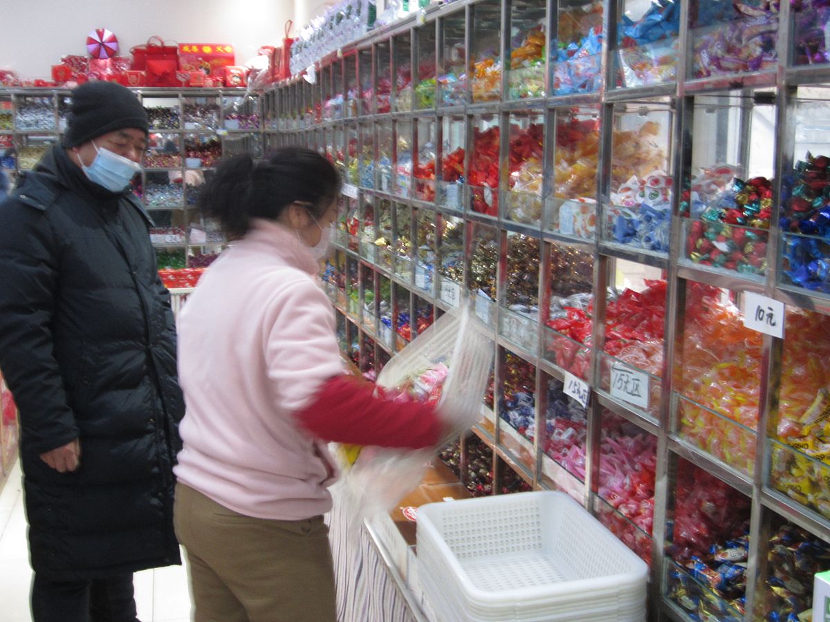 2021年12月23日,黑龙江黑河,市民在爱辉区四兴食品超市选购糖果.