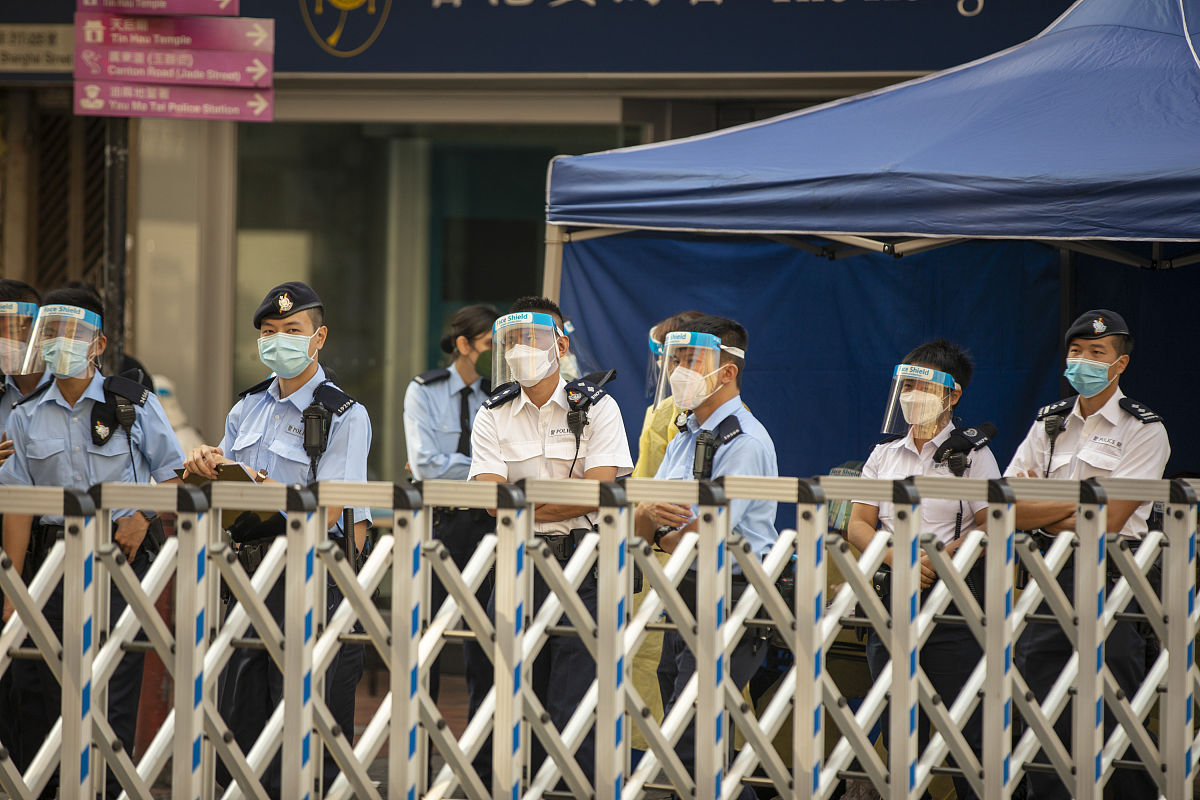 2021年1月23日,香港佐敦区,警察拉闸封路,医护人员在临时检测点开始工