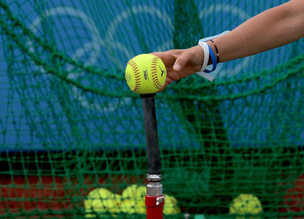 unidentified italy's softball player puts a ball onto the tee at