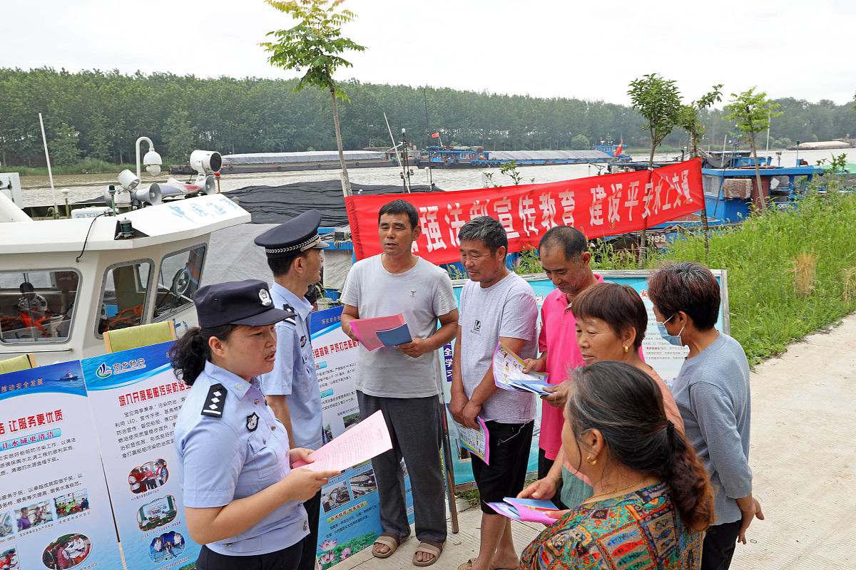 用50字描述在烈日下民警向群众宣传知识的场景