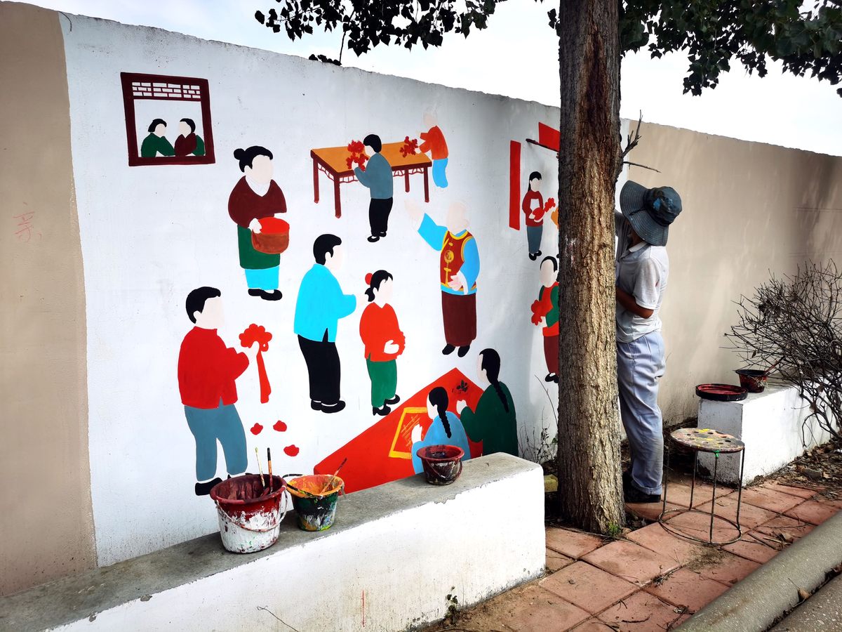 新南社区党员带领小朋友绘墙画，社区墙壁添亮色