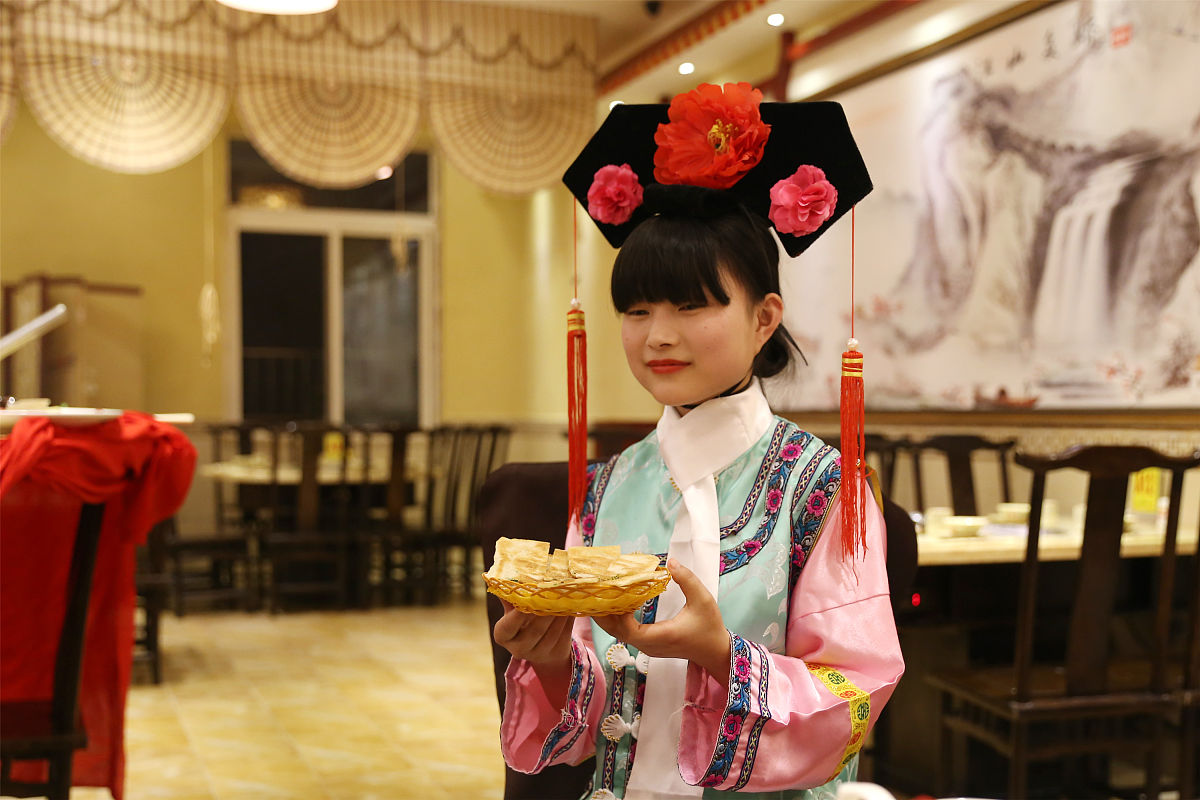 2016年4月21日,湖北省宜昌市一家餐饮店的"格格"服务员为品尝大火锅佳