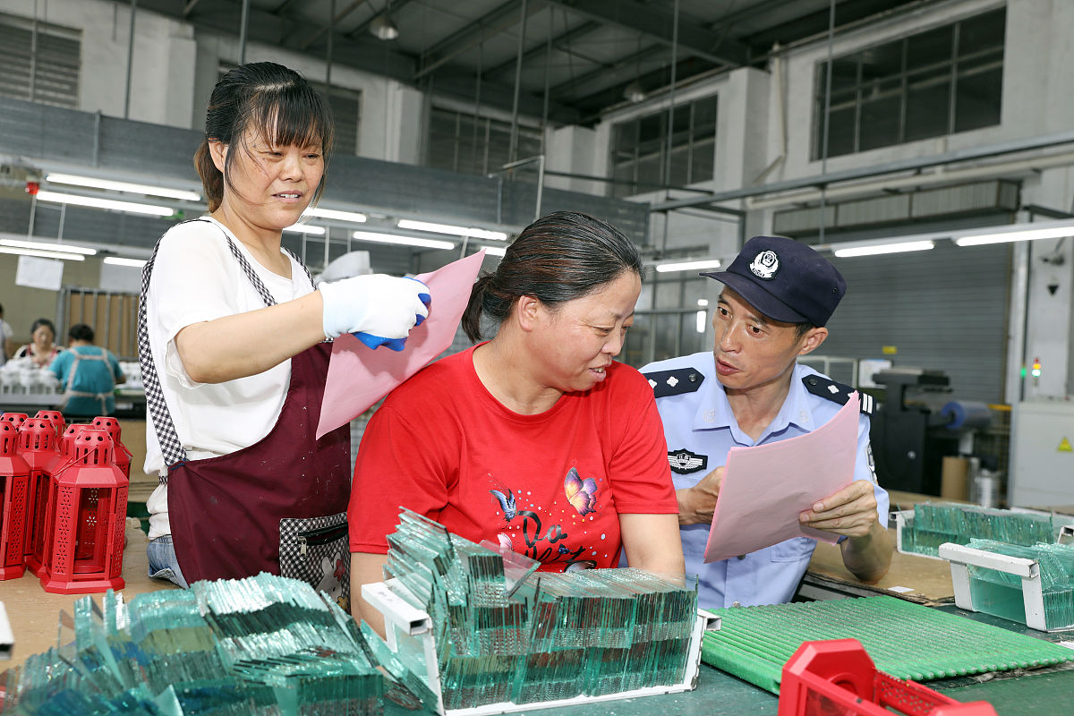 2021年7月14日,江苏扬州,民警在宝应县安宜镇一家企业车间里,向职工宣