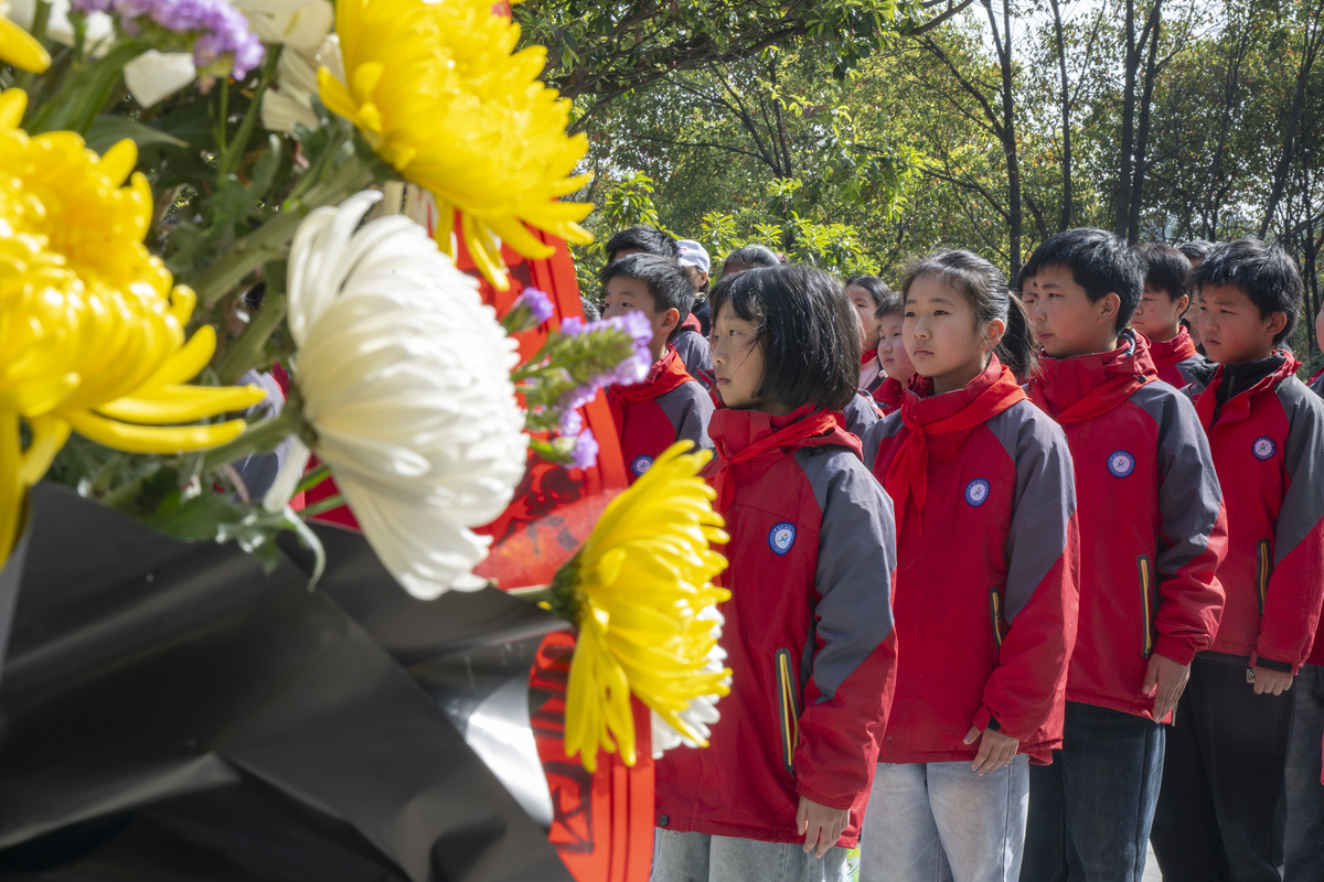 学校清明节扫墓新闻稿 关键字：乘坐校车出发献花篮默哀