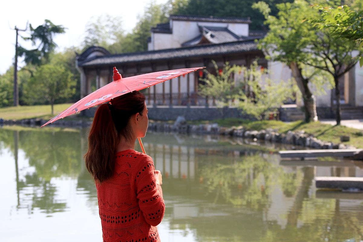 古镇小桥红衣女子撑伞哭泣场景描写