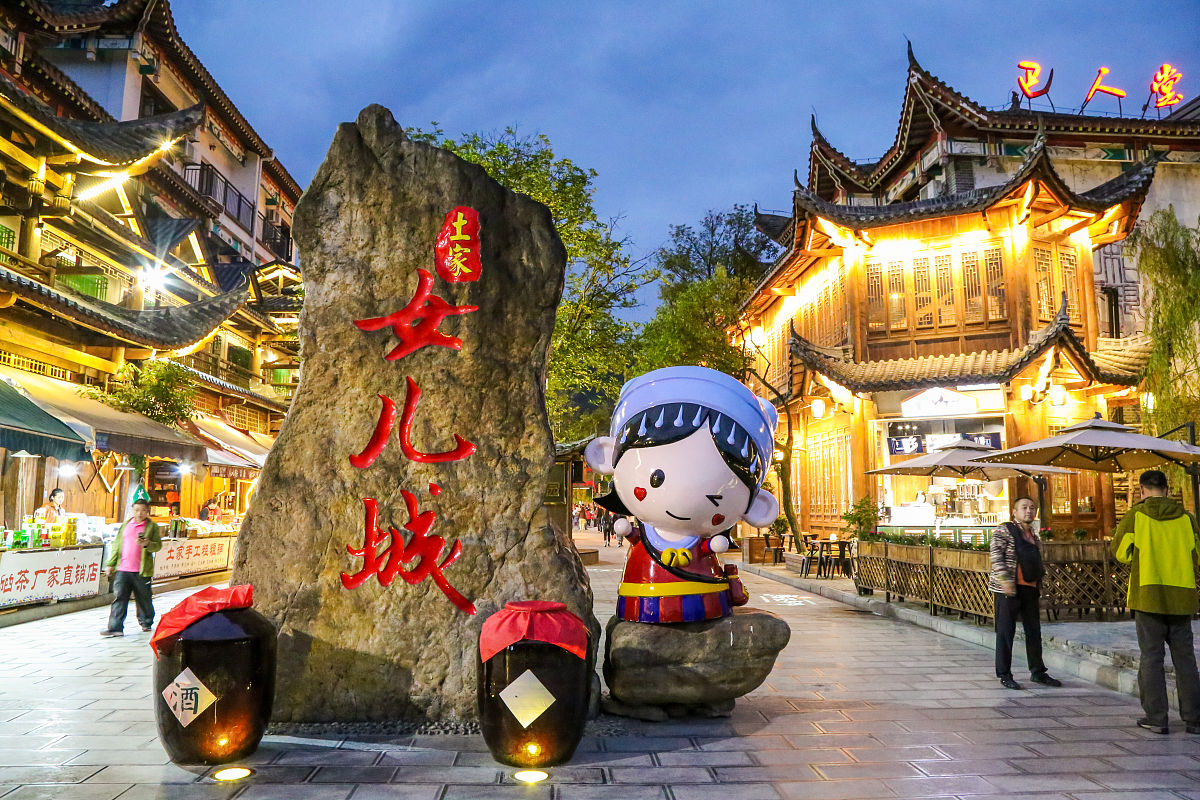 大家好欢迎来到恩施女儿城！我是你们的导游小X今天我将带领大家游览这个具有浓郁土家族风情的文化旅游胜地。恩施女儿城位于湖北省恩施市占地面积约200亩是一座集文化、旅游、休闲、购物于一体的综合性景区。这里的建筑风格以土家族民居为主保留了大量传统的建筑形式和风格充满了浓厚的土家族文化气息。首先我们来到了女儿城的中心广场。这里是游客聚集的地方不仅可以欣赏到表演和各种文艺活动还能品尝到各种土家族特色小吃。现