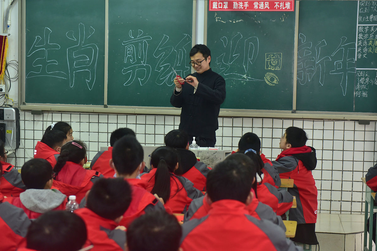 2020年12月29日,四川省内江市东兴区初级中学校的老师指导学生剪纸.