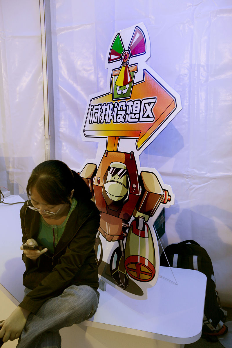 2011年9月16日,北京科学嘉年华上,观众在减排设想区打手机发短信.