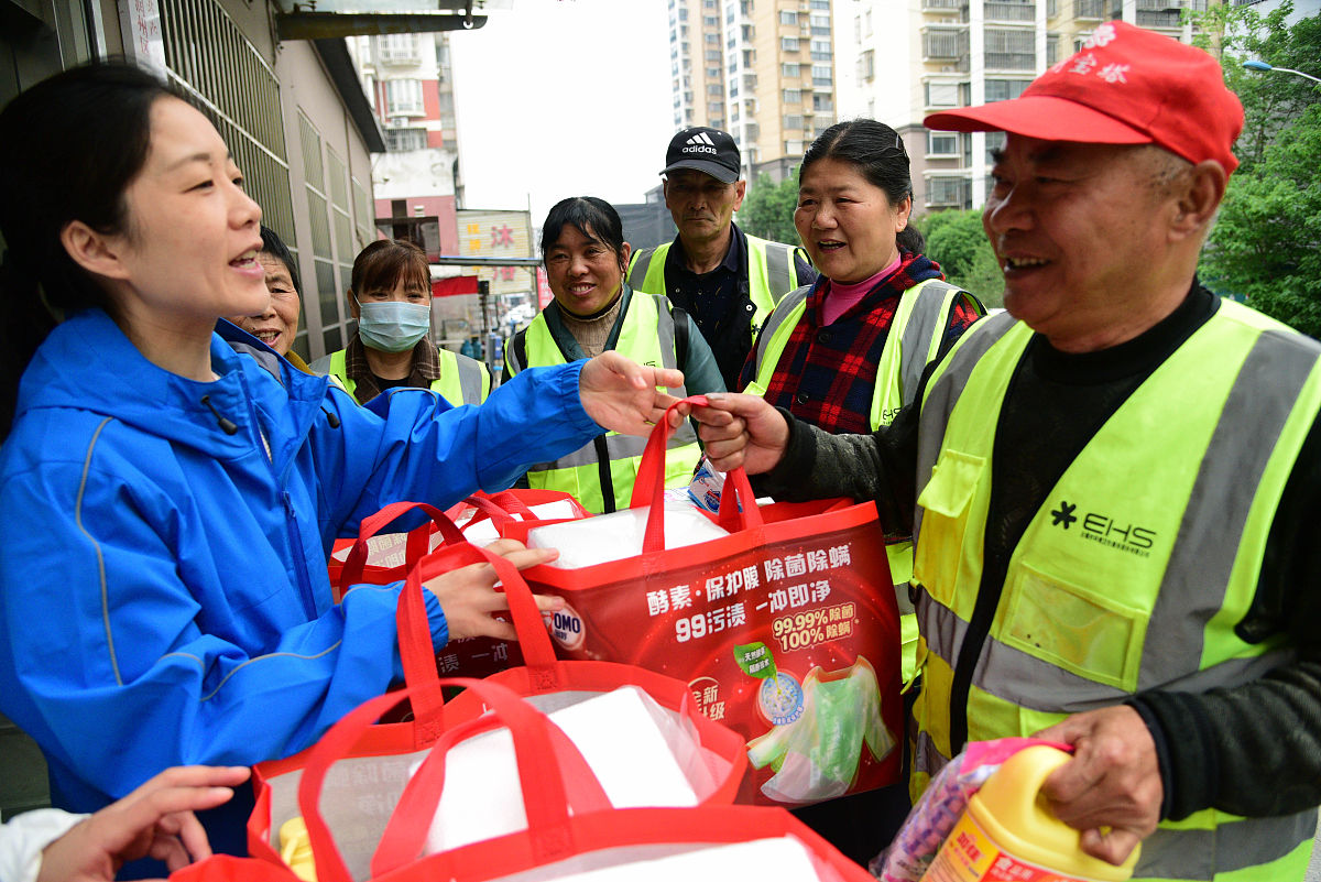 2021年4月26日,江苏镇江,在二道巷社区,工作人员在向街巷保洁员赠送保