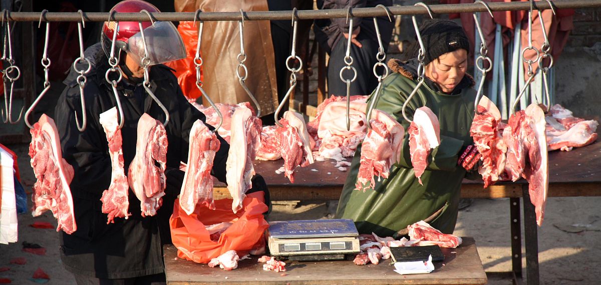 12月9日,市民在山东聊城光明蔬菜批发市场选购猪肉.