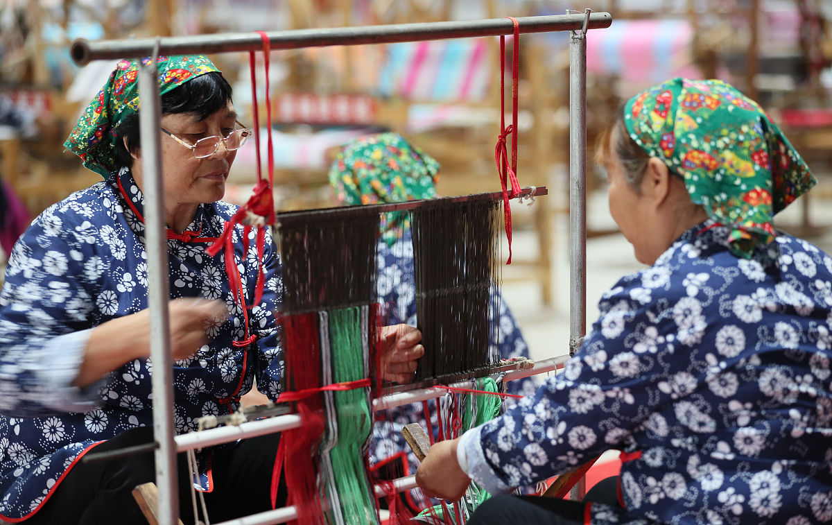 2019年6月5日,山西运城,永济市开张镇<strong>东</strong>开张村村民在织布机上制作手工