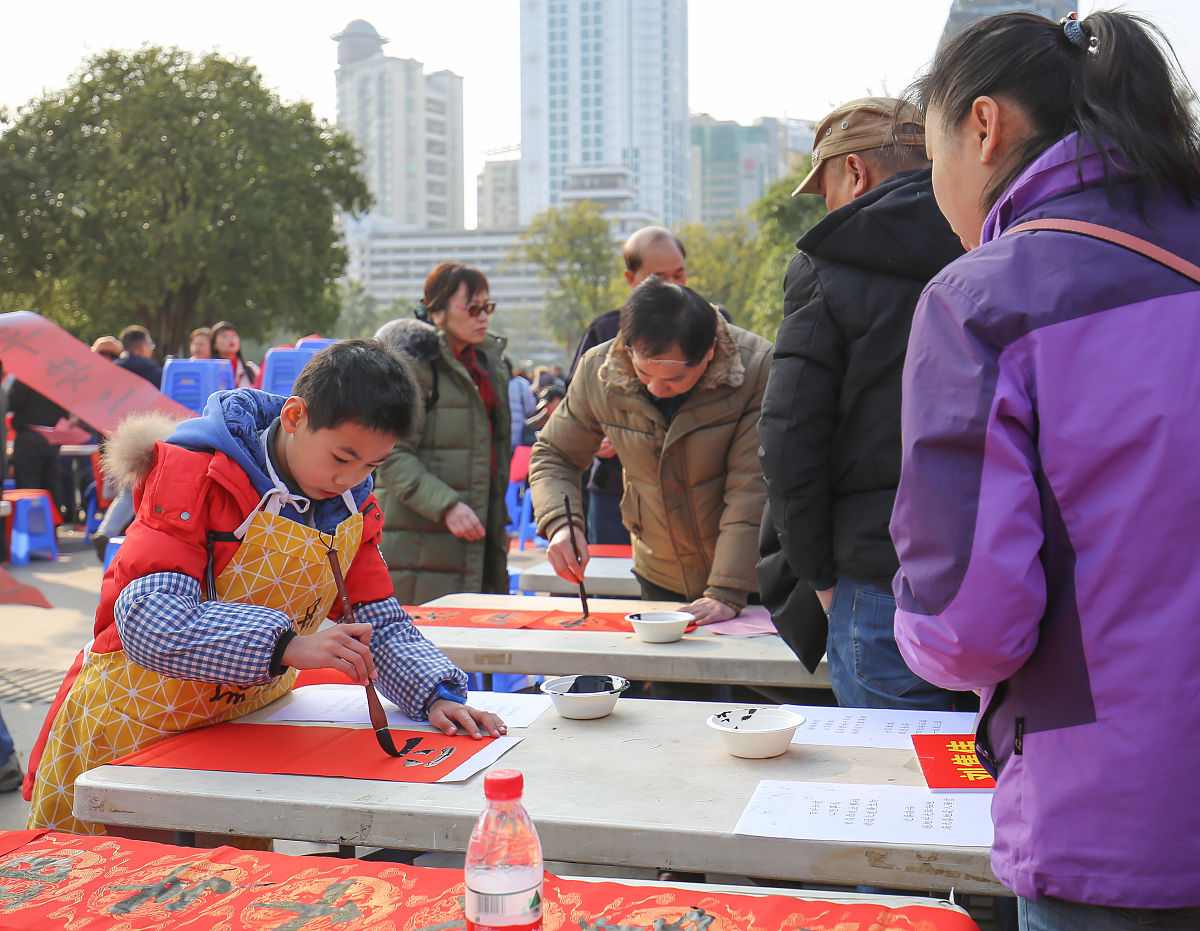 2018年2月3日,广西柳州,少年书法家为市民书写春联.