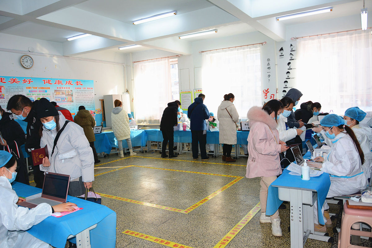 2021年12月4日,吉林省吉林市船营区第二小学的学生在家长的陪护下走进