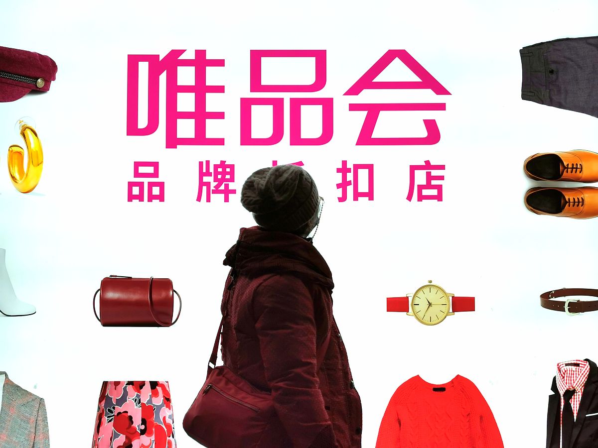 2021年2月19日,上海,路人夜晚从唯品会的商店前走过.