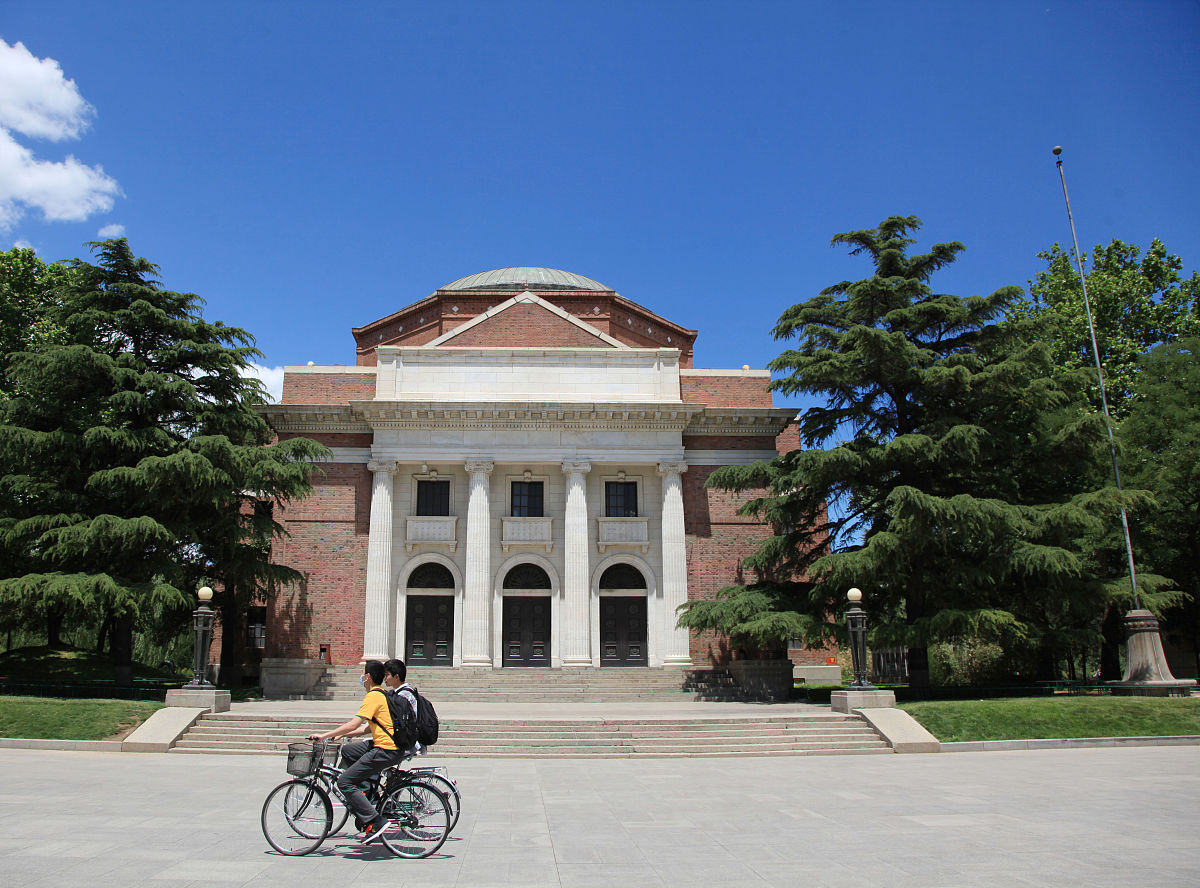 2021年6月4日,北京,清华大学,学生们骑着自行车从老礼堂前驶过.