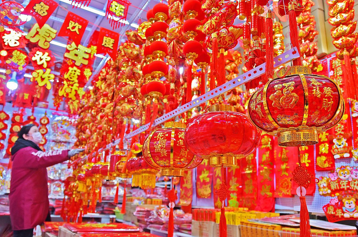 2021年12月30日,市民在山东烟台三站节庆用品市场选购新年饰品.