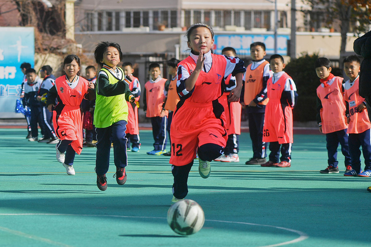 2021年11月11日,在青岛普集路小学组织的足球对抗赛上,一名红衣队员带