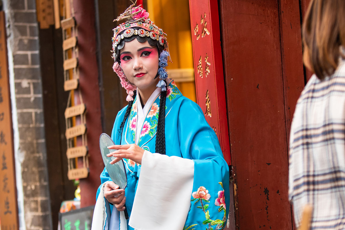 2018年3月22日,重庆磁器口,身着戏服招揽客人的茶馆员工.