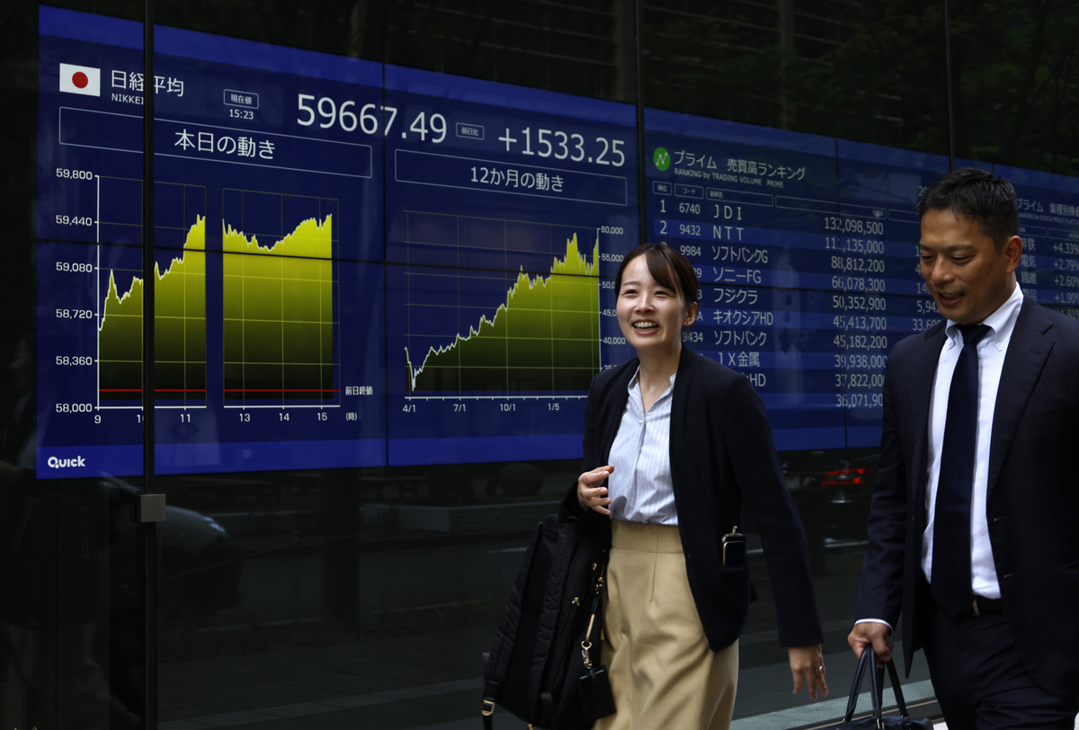 当地时间2026年4月16日,日本东京,路人走过一处股市牌