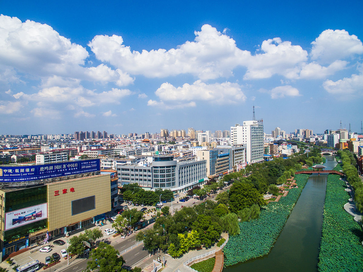 2018年7月16日,河南许昌,蓝天白云下的许昌市建设路护城河畔与盛开的