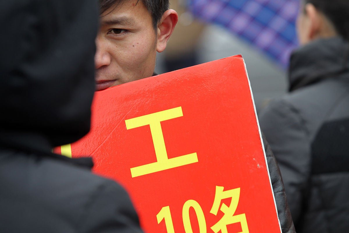   2014年2月19日,众多举着招工牌子的家纺企业招工人员聚集在江苏南通