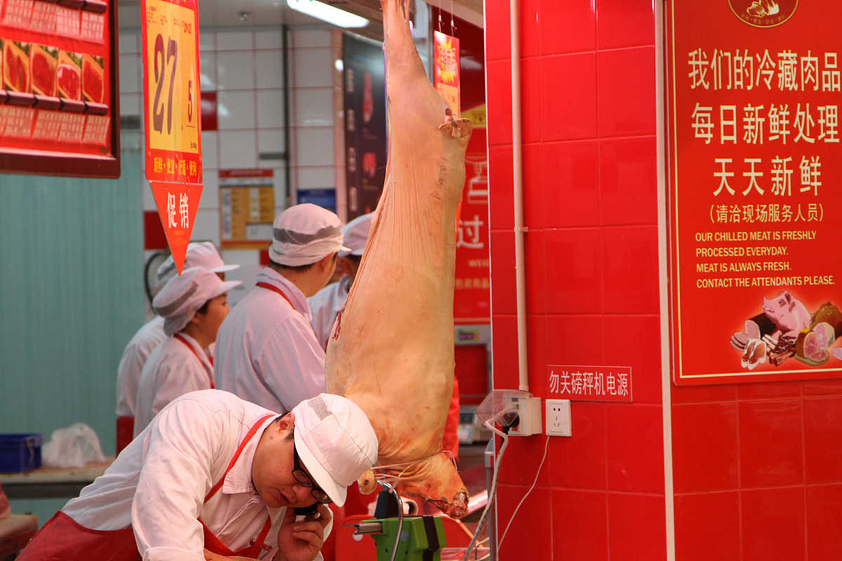   2012年12月29日,市民在江苏省南通市一超市选购猪肉.牌子上写着"我