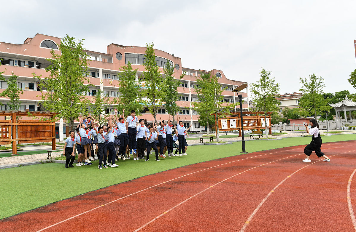 2021年5月24日,浙江省东阳市江北中心小学月亮湾校区操场上,老师在帮