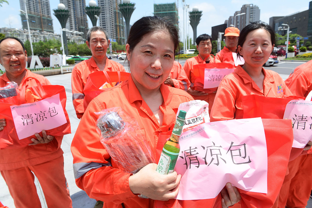 2021年7月13日,安徽阜阳,环卫工人们高兴地领到单位统一发放的高温"清