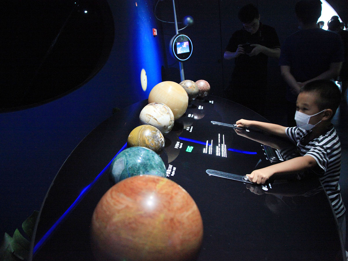2021年7月22日,一名小朋友在上海天文馆的一个宇宙星球互动装置前体验