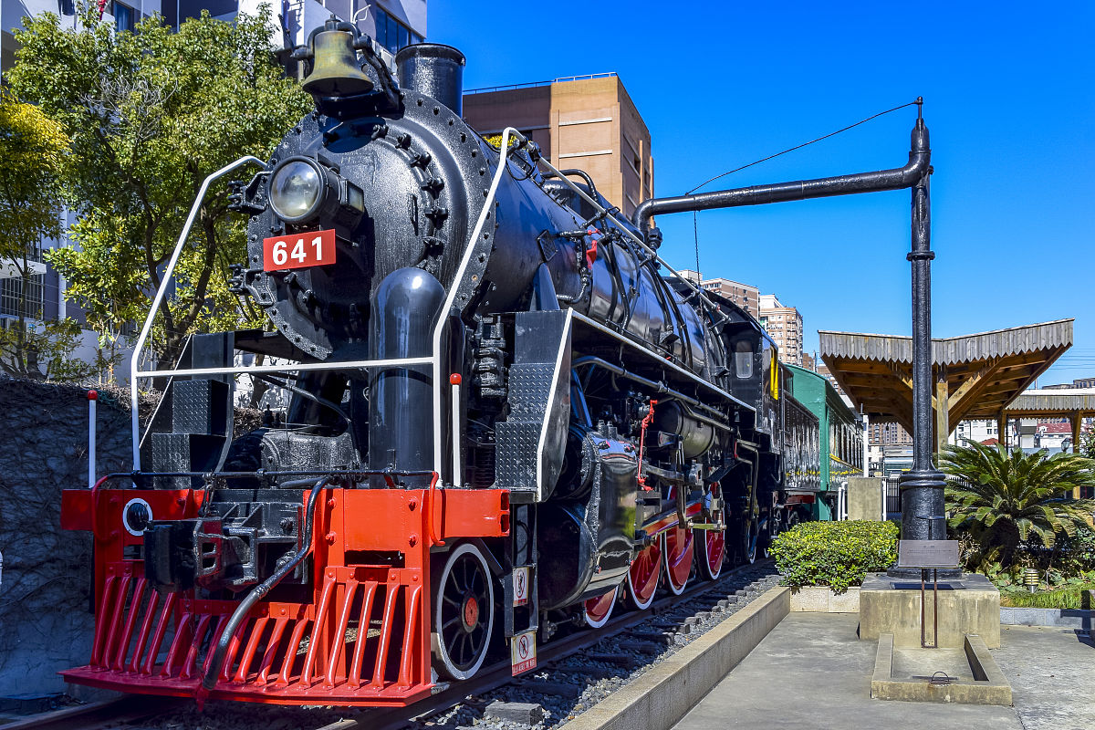 请问如果存在一座铁路博物馆酒店它旁边就是一条废弃的铁路一层有餐饮、咖啡厅、休闲活动等功能空间该怎样描述其街景活动的场景？