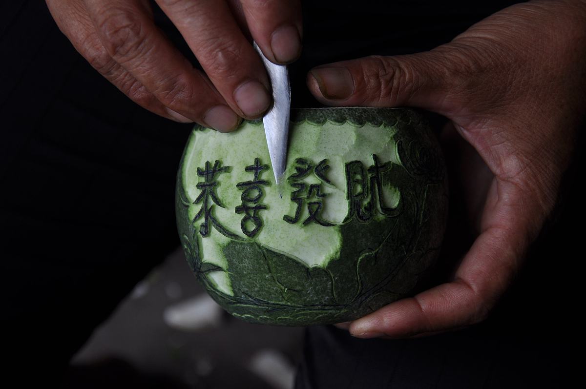 2012年8月16日,湖南省靖州自治县艮山口夏乡村农民用未成熟的柚子在雕