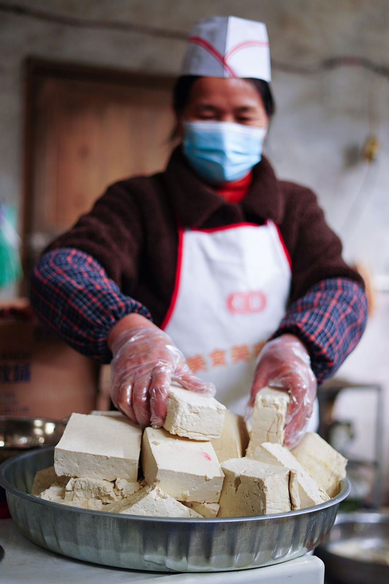 2022年1月17日,贵州黔东南,兴仁村,村民在选取制作"血豆腐"的豆腐.