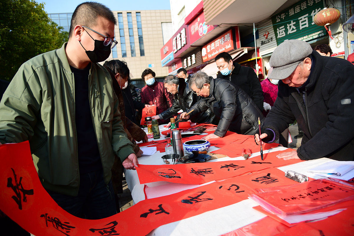 2021年2月3日,在江苏省镇江市金星社区,书法家在为居民书写廉政春联.
