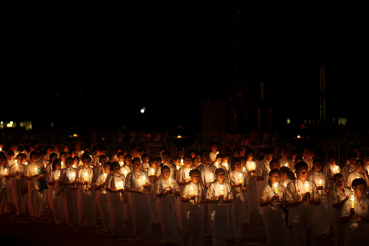 2012年3月7日,泰国巴吞他尼府,数千名僧侣坐在灯烛旁诵经,庆祝万佛节.