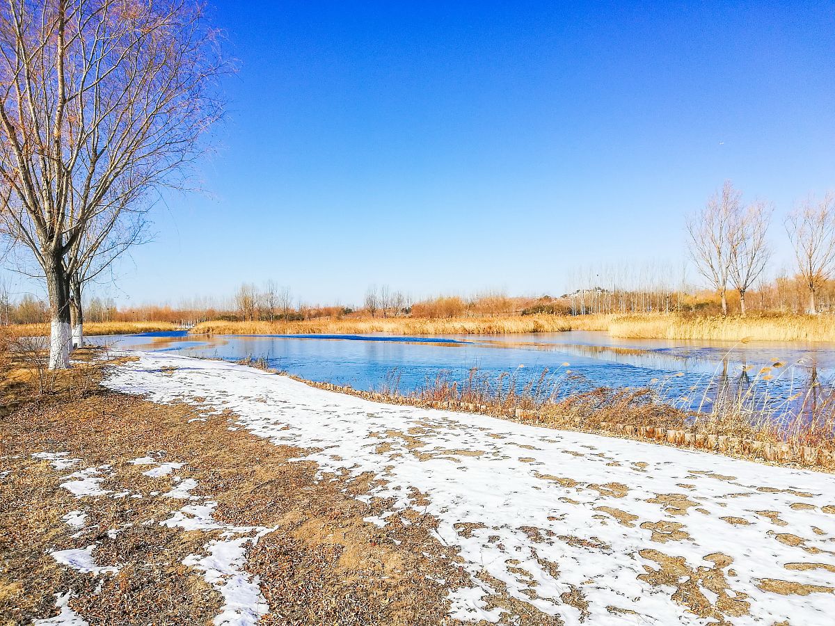 2019年12月3日,北京天气晴好,昌平区未来科学城滨水公园残雪未消,湖水